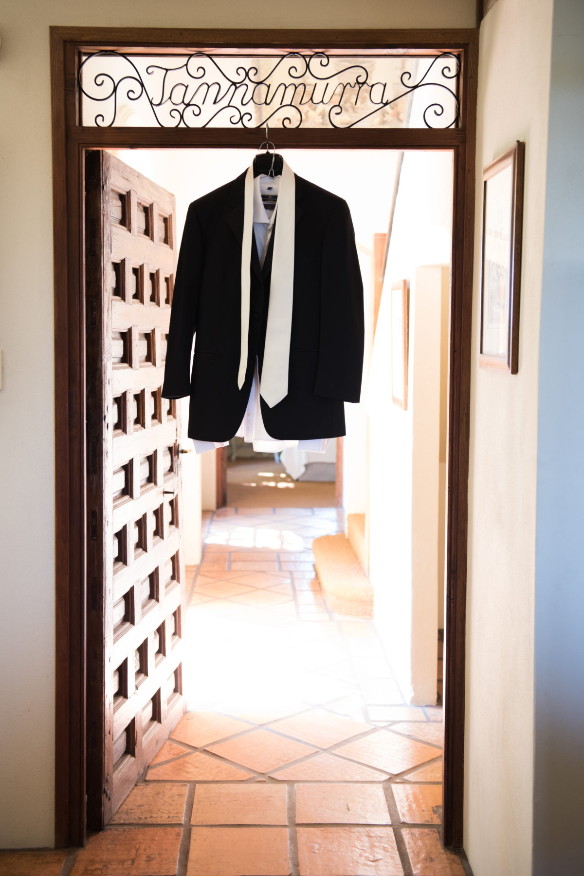 Groom's suit coat hanging in door frame with Tannamurra sign