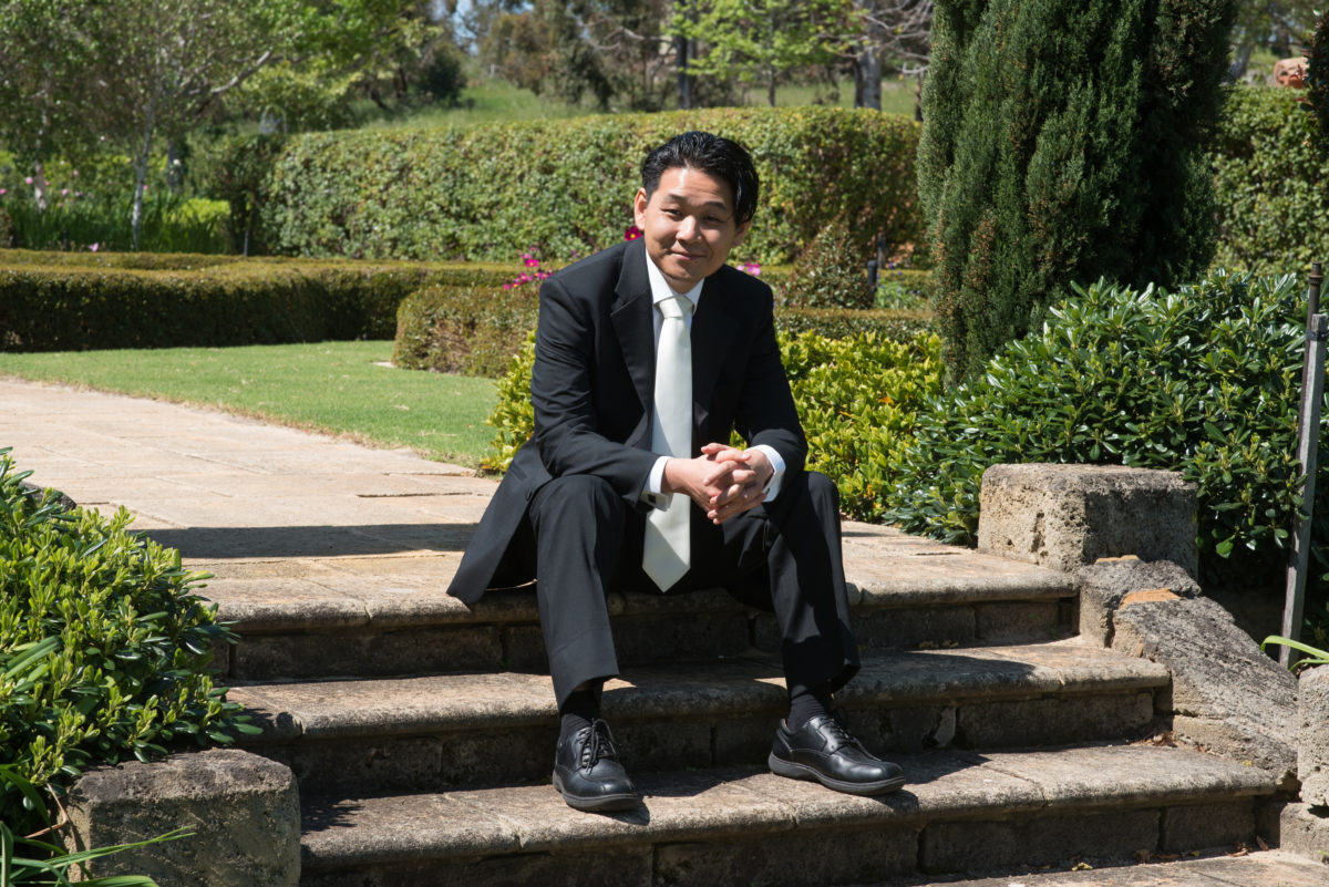 Groom sitting on outdoor steps smiling art camera, in tuscan garden Tannamurra swan Valley Perth