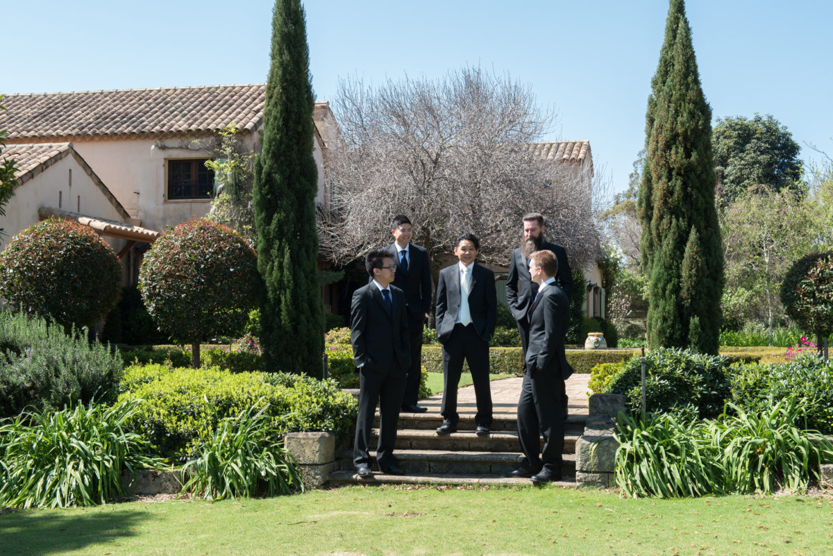 Groom and groomsmen standing in Tuscan garden showing outside of Tannamurra
