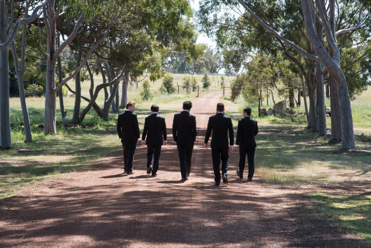 Groom and groomsmen wallking down a country lane at Tannamurra, Swan Valley Perth