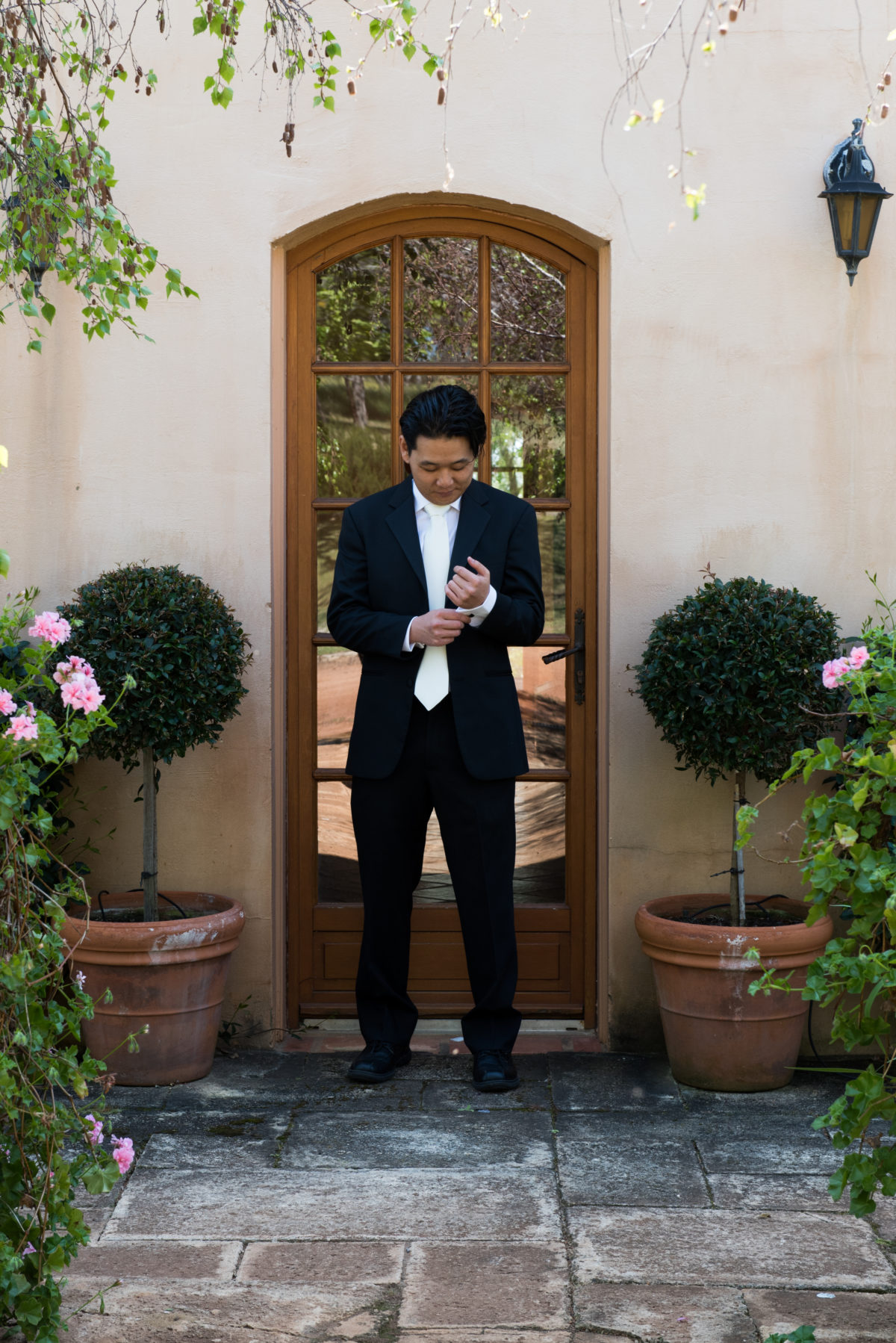 Groom standing in doorway of tuscan style house. Tannamurra groom getting ready