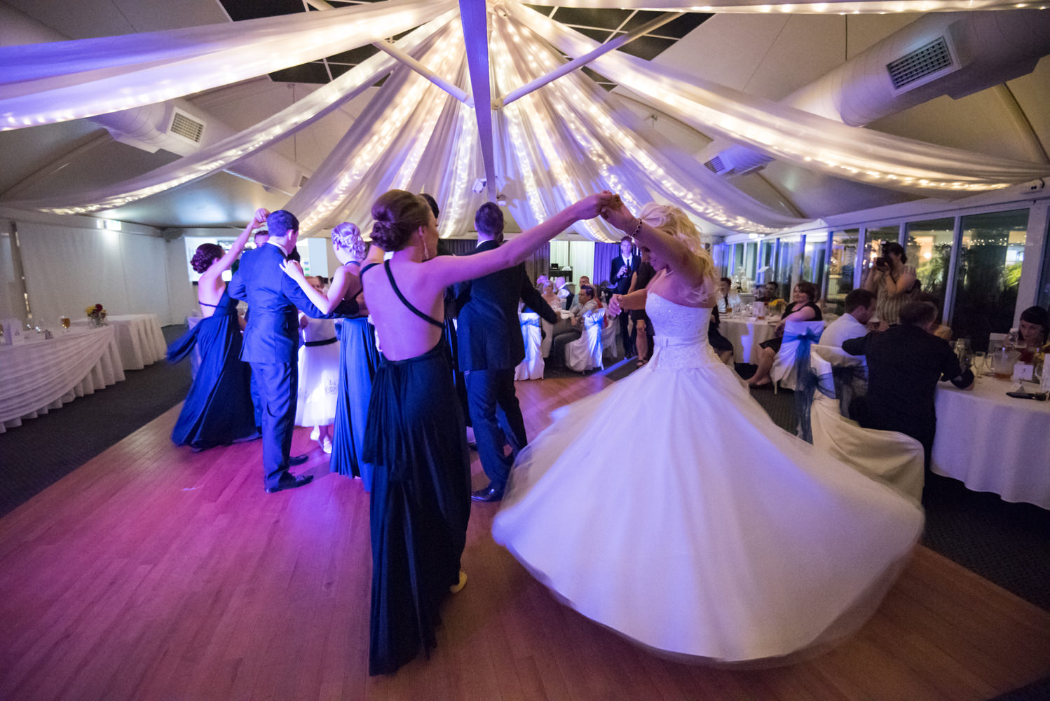 bridesmaid twirling the bride on the dance floor at Joondalup resort
