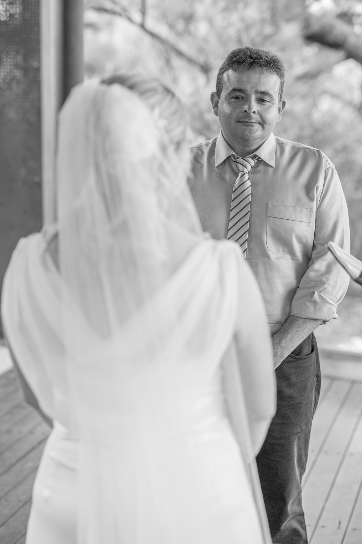 Black and white photo of groom looking at bride during ceremony