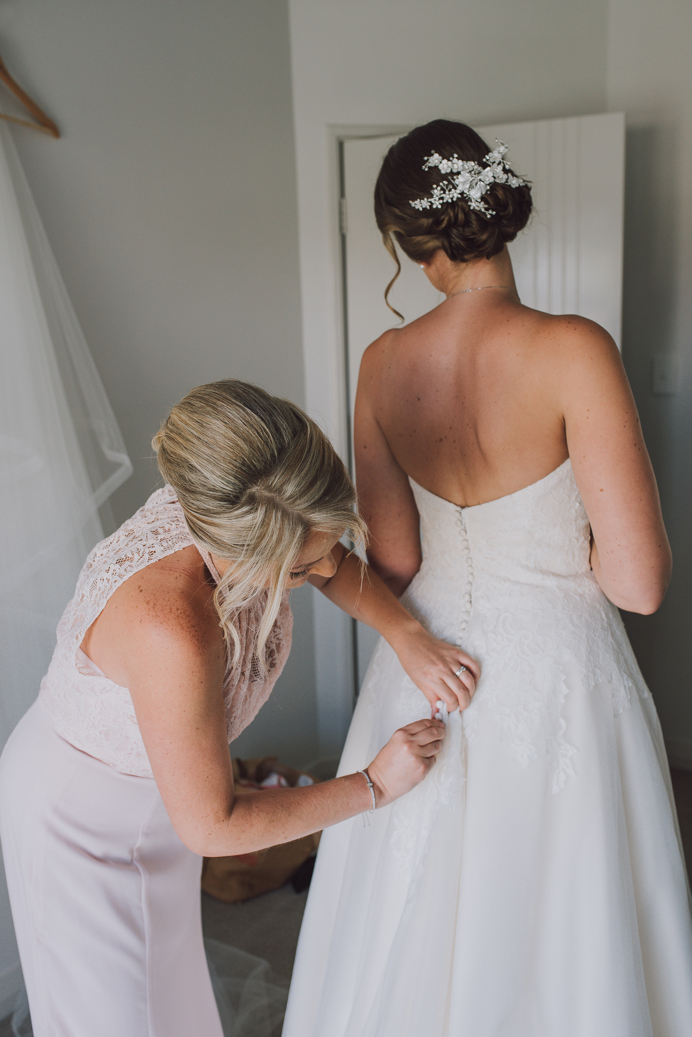 bride having her dress done up
