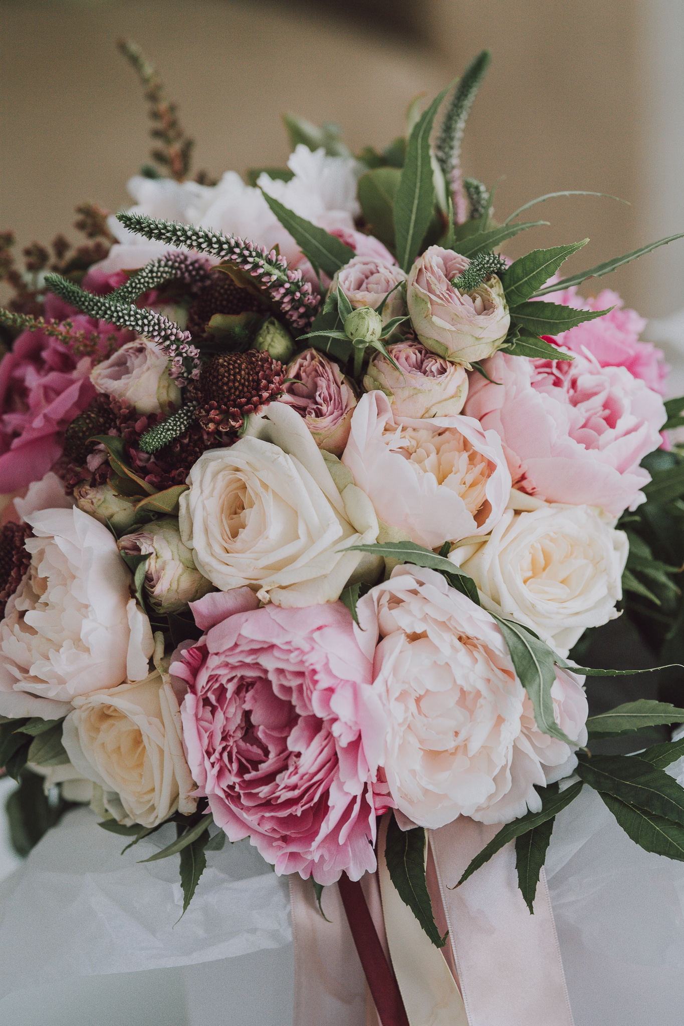 closeup of wedding bouquet with pink peonies and white roses
