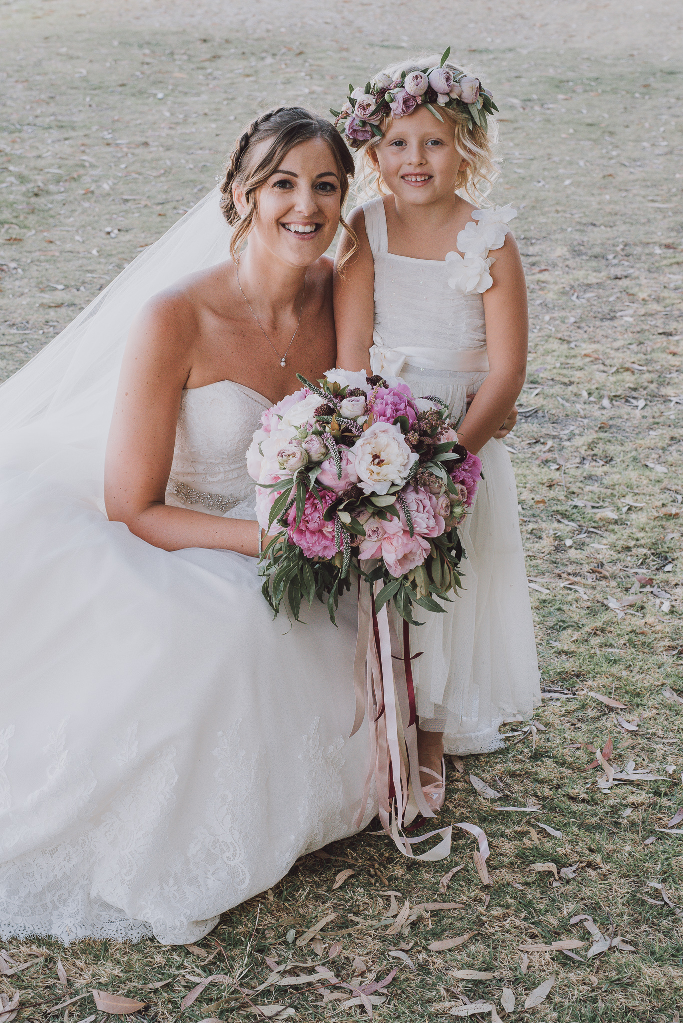 bride crouching beside her flower girl