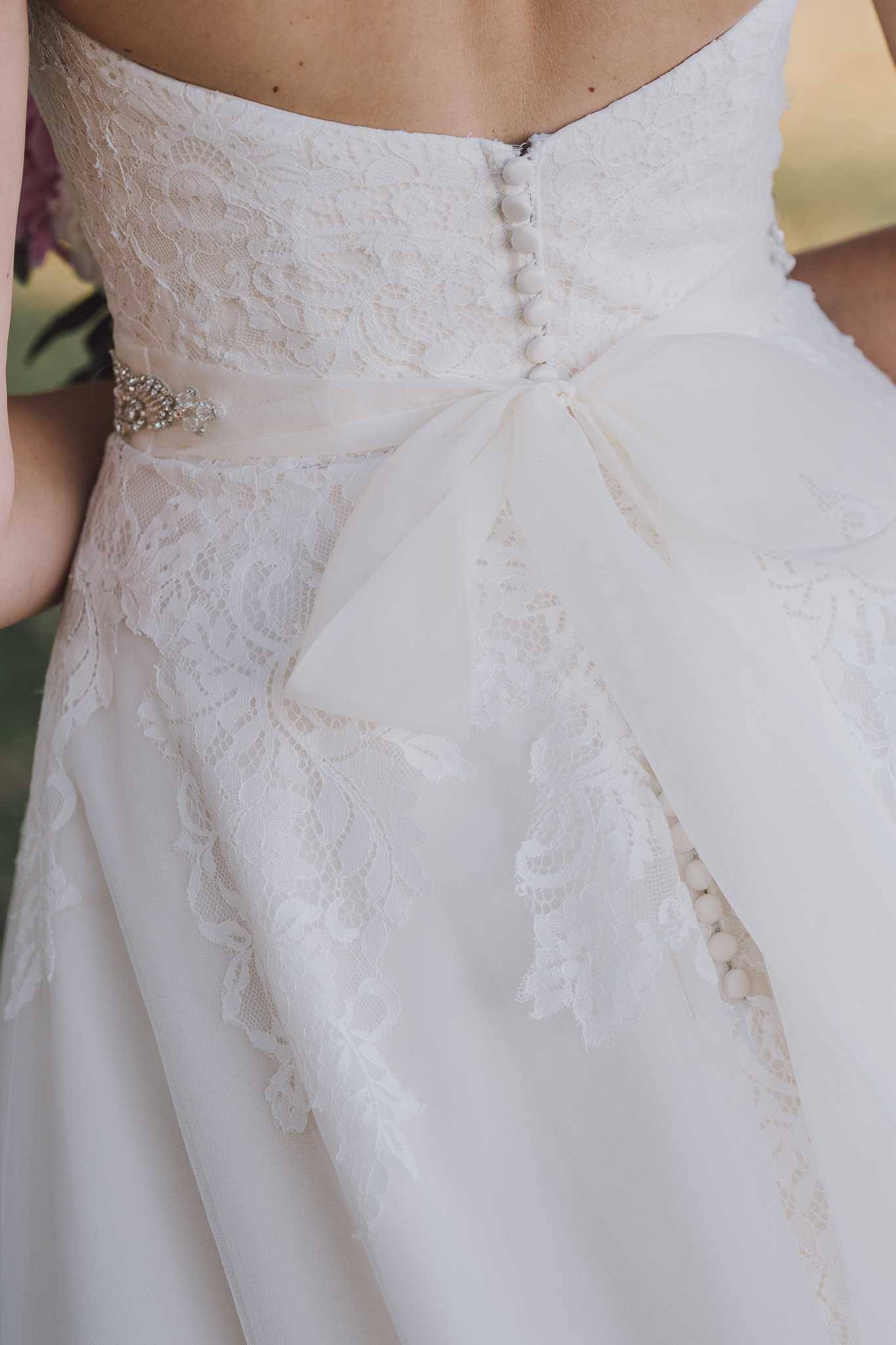 close up detail of back of bride's wedding dress bow
