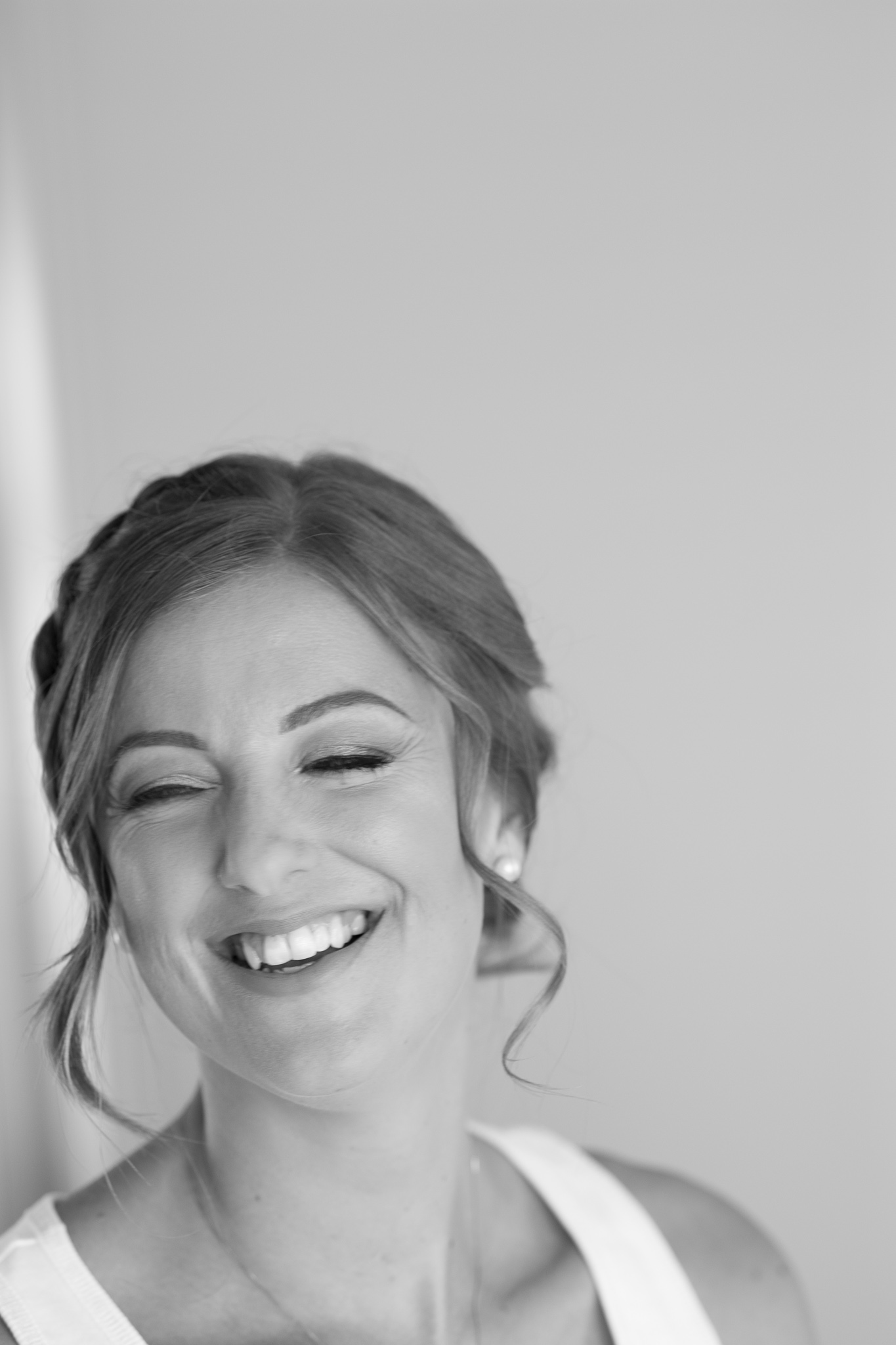 bride with her eyes closed laughing
