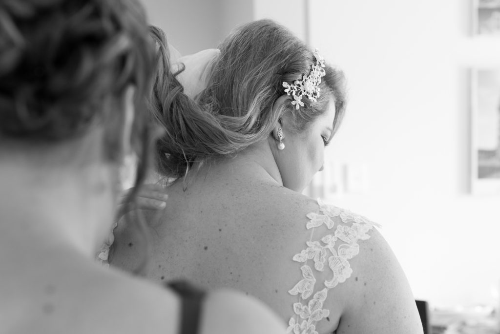 bride getting wedding dress on looking down