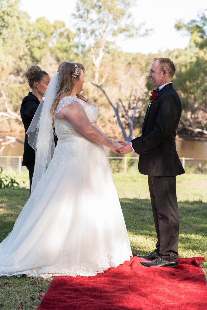bride and groom holding hands during wedding ceremony