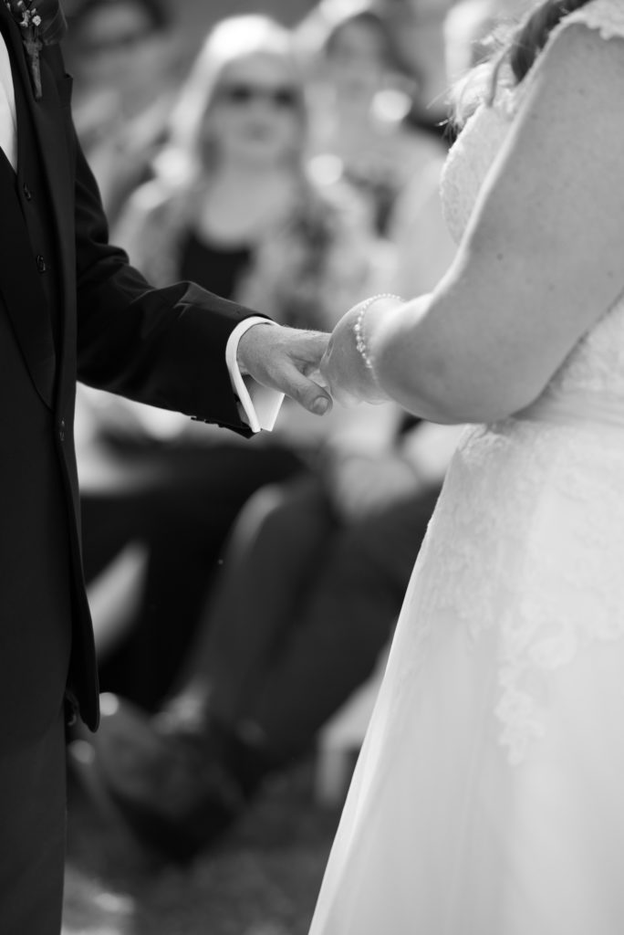 bride putting groom's ring on