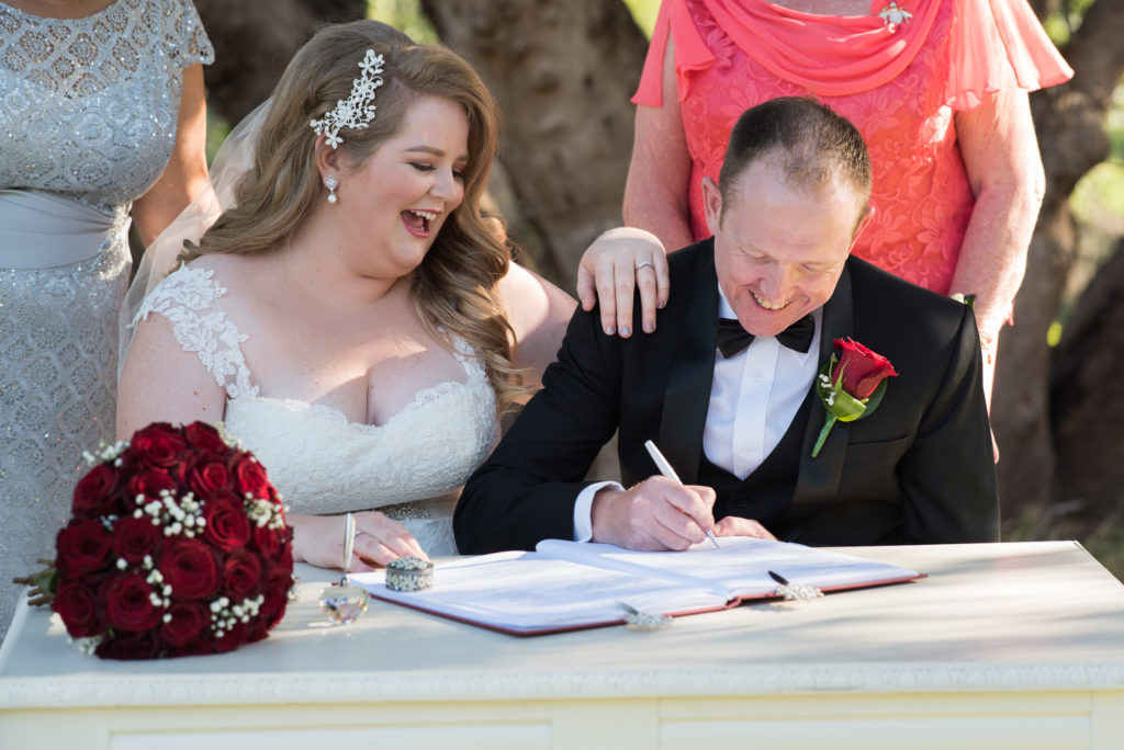 groom signs the wedding certificate